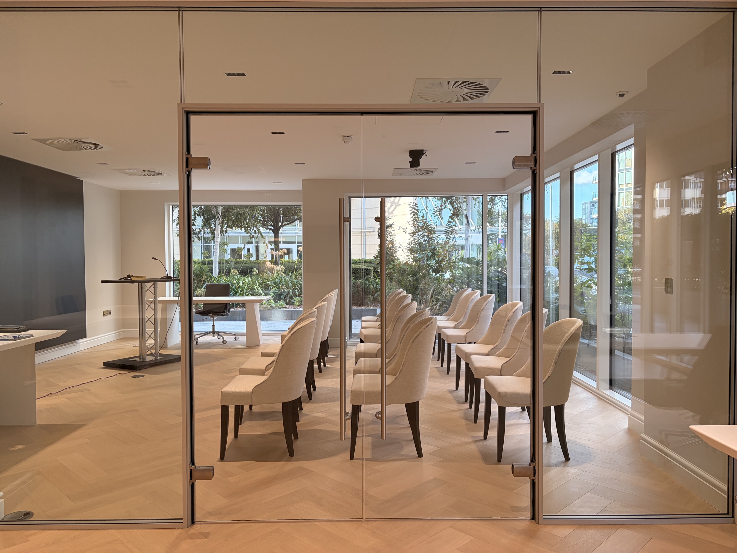 The glass entrance to the auction room at London Auction Centre, rows of seating facing the rostrum
