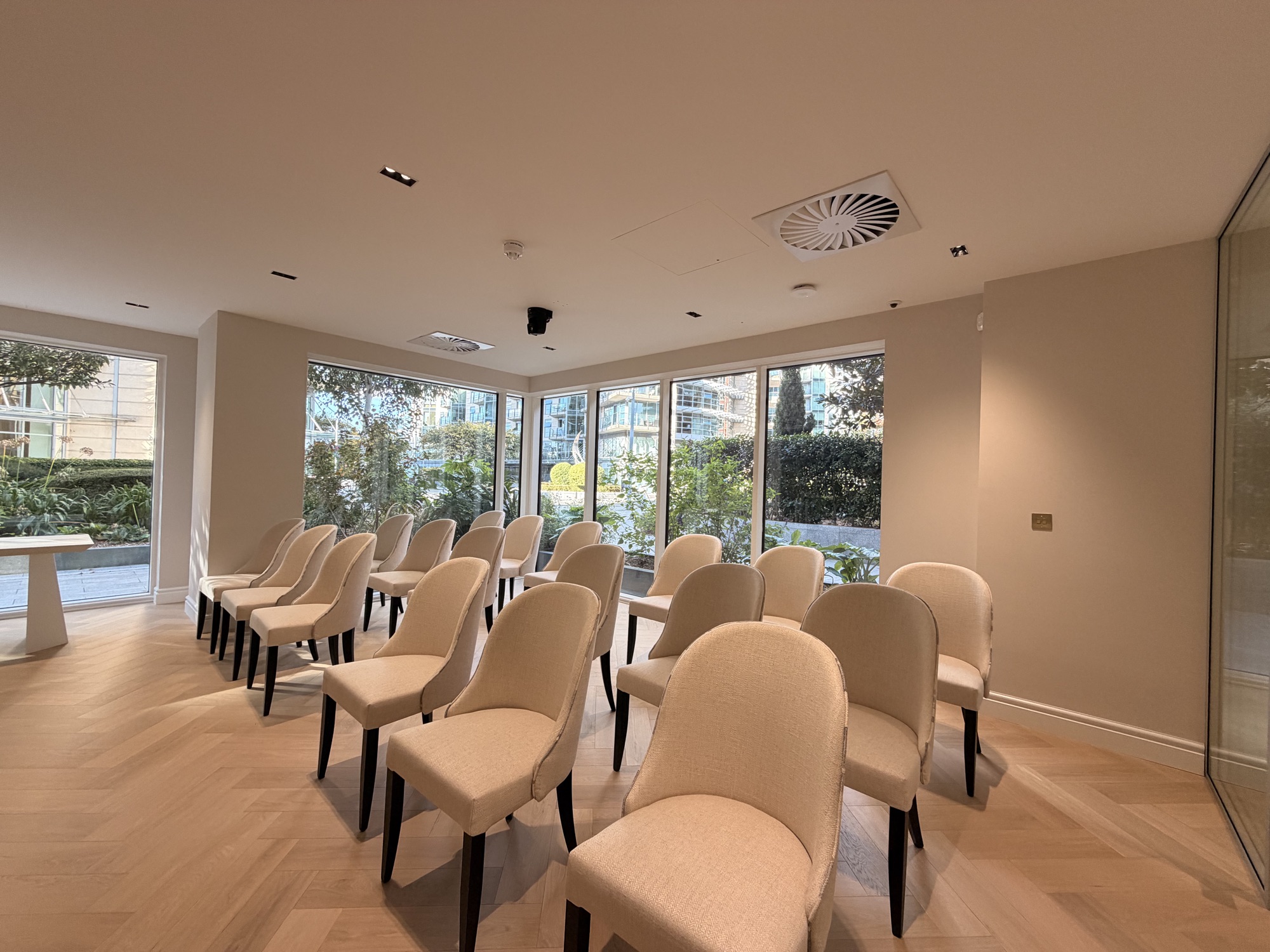 Rows of seating in the auction theatre beside floor-to-ceiling garden windows